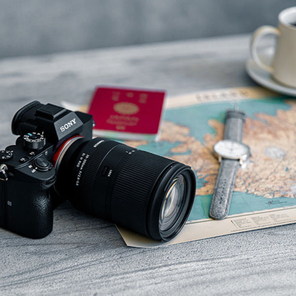 Camera on a table with a map, coffee cup, and hat
